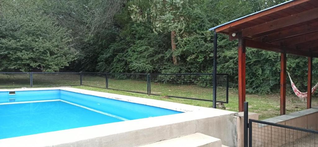 a swimming pool in a yard with a fence at Casita de los recuerdos in Villa Carlos Paz