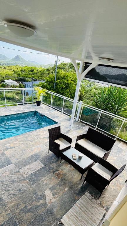 un patio con tavolo e sedie e una piscina di Panorama180 a Le Marin