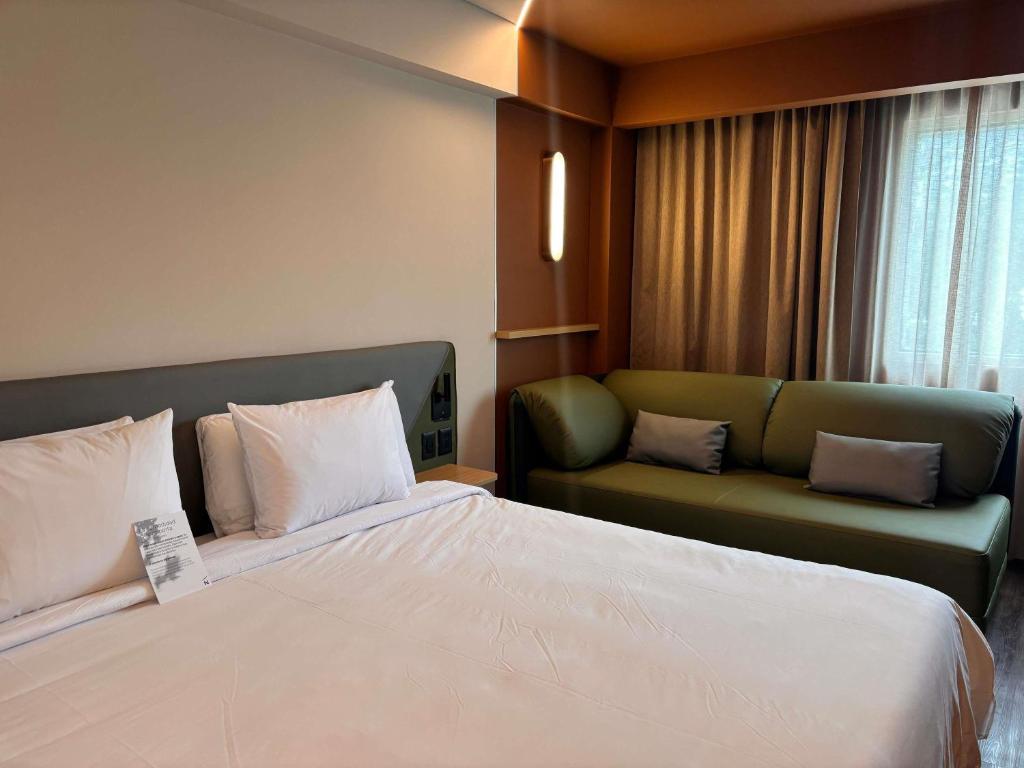 a hotel room with a bed and a couch at Novotel Monterrey Valle in Monterrey