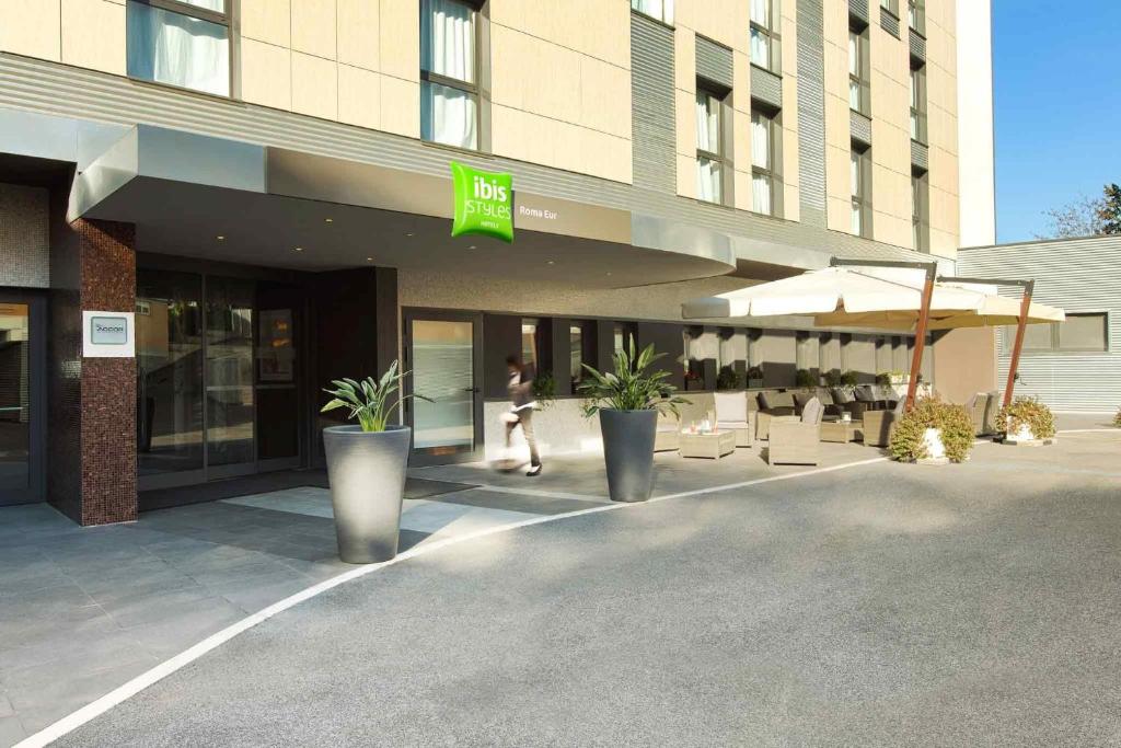 a person walking in front of a building at Ibis Styles Roma Eur in Rome
