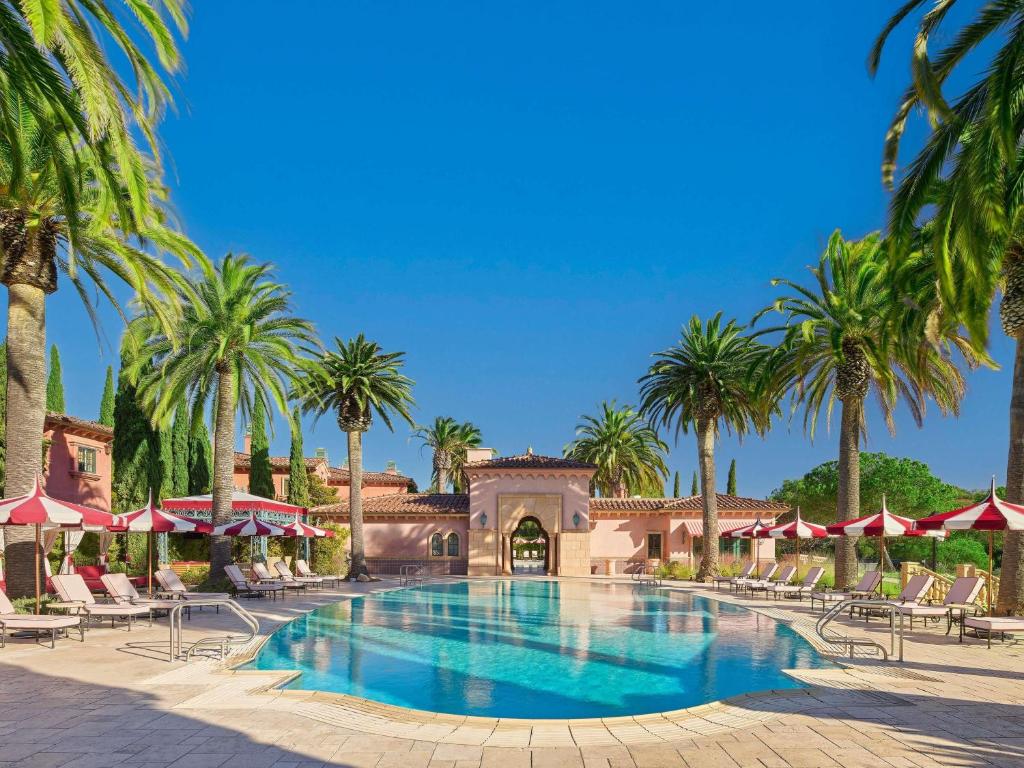 a pool at a resort with palm trees at Fairmont Grand Del Mar in San Diego