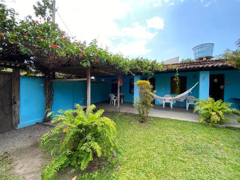 a blue house with a hammock in the yard at Pousada do Caminho Trancoso in Porto Seguro