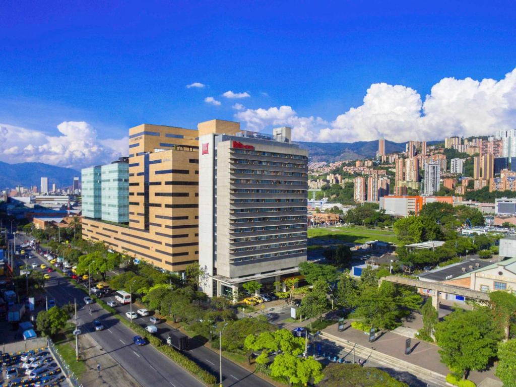 ein hohes Gebäude in einer Stadt mit einer Straße in der Unterkunft ibis Medellin in Medellín