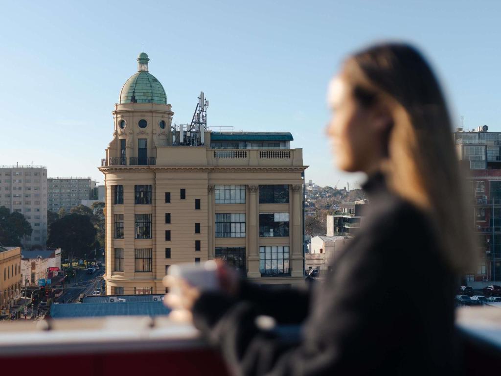 una mujer parada frente a un edificio en The Cullen Melbourne - Art Series, en Melbourne