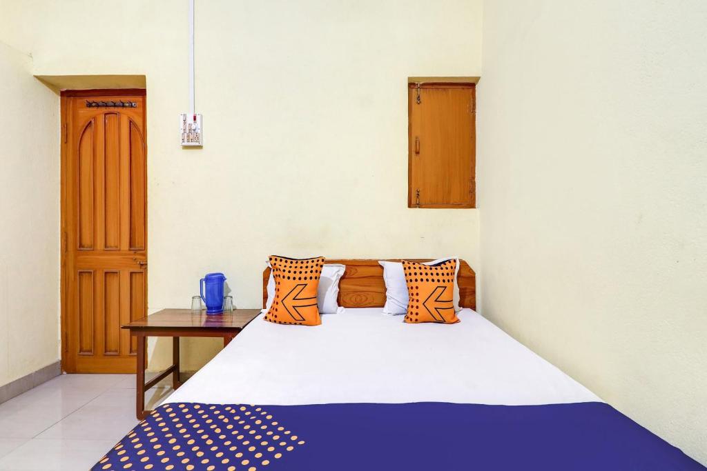 a bedroom with a bed and a wooden table at Hotel O Shivaye Rest House in Deoghar