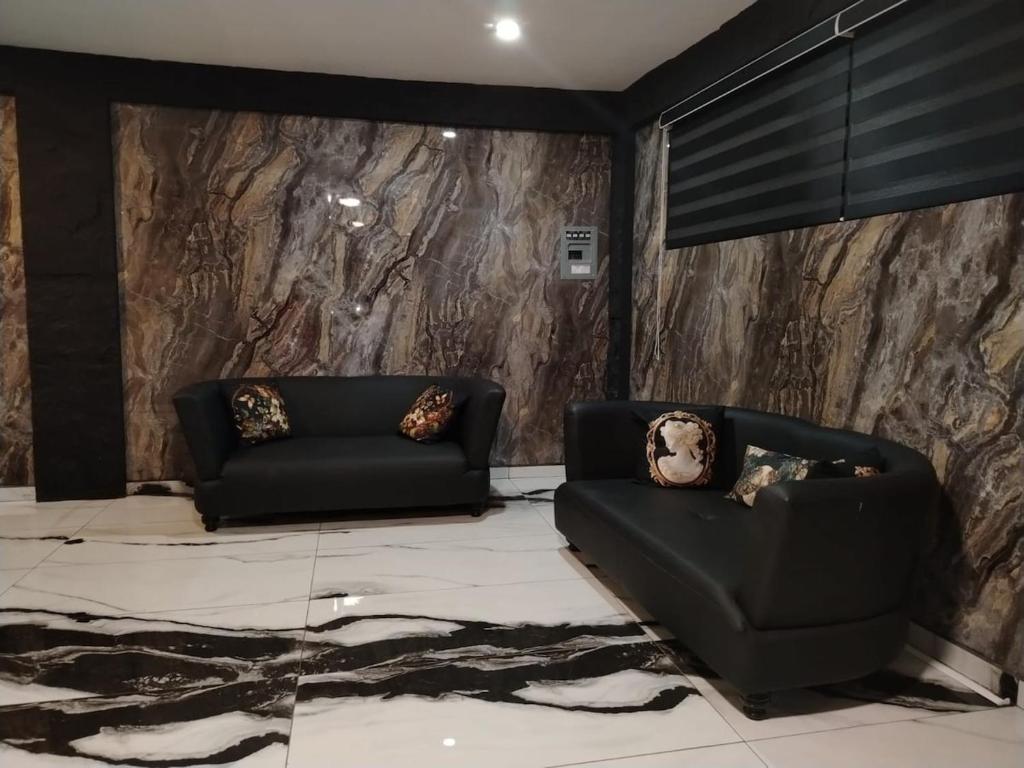 - un salon avec deux canapés noirs et un mur en pierre dans l'établissement Río 3 Spacious Loft with incredible river views, à Tierra Colorada