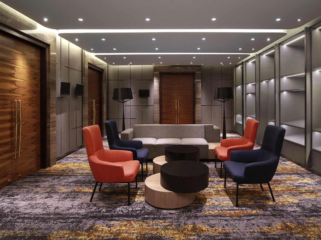 a lobby with a waiting room with chairs and a table at Novotel Jakarta Mangga Dua Square in Jakarta