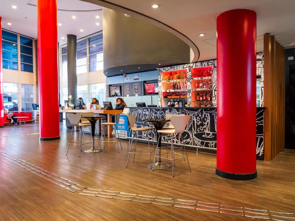 a restaurant with red columns and a bar at ibis Campinas in Campinas