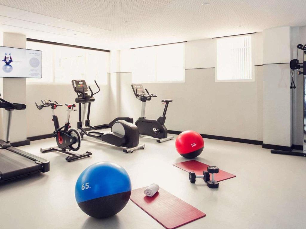 a gym with several exercise bikes and exercise balls at Pullman Madrid Airport & Feria in Madrid