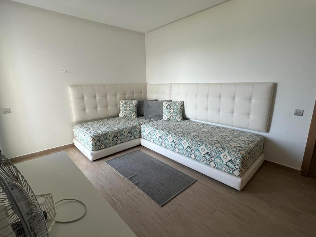 a bedroom with two beds in a room at Luxurious Seaside Apartment in Sidi Bouqnadel