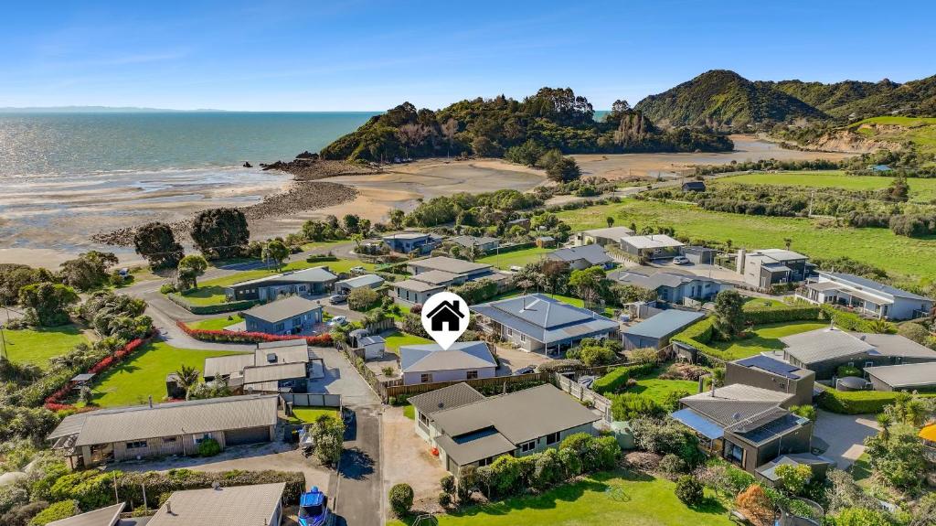 eine Luftaufnahme eines Hauses am Strand in der Unterkunft Penguin Cottage in Tarakohe