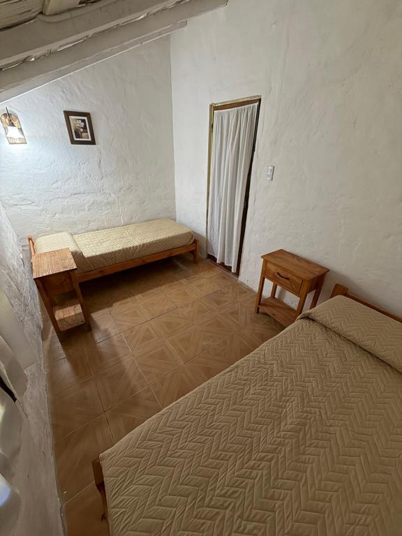 コロニア・カルロス・ペジェグリニにあるHostel El Paso Iberaのベッド2台とベンチがある部屋