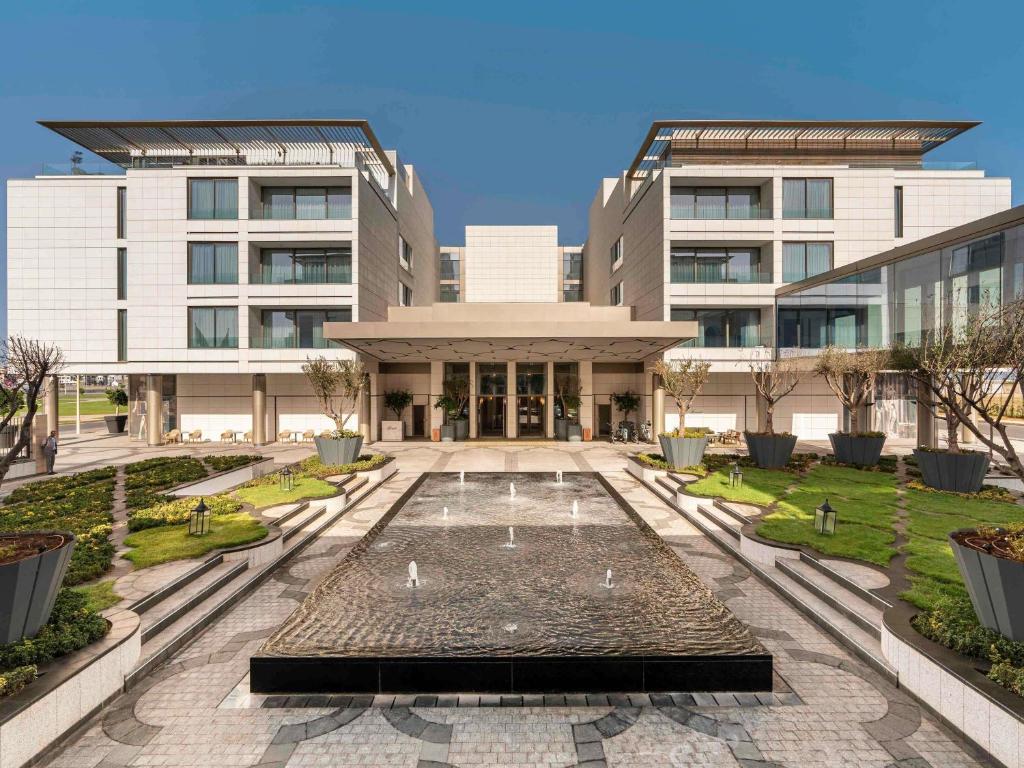 ラバトにあるFairmont La Marina Rabat Sale Hotelの建物の前に噴水がある建物