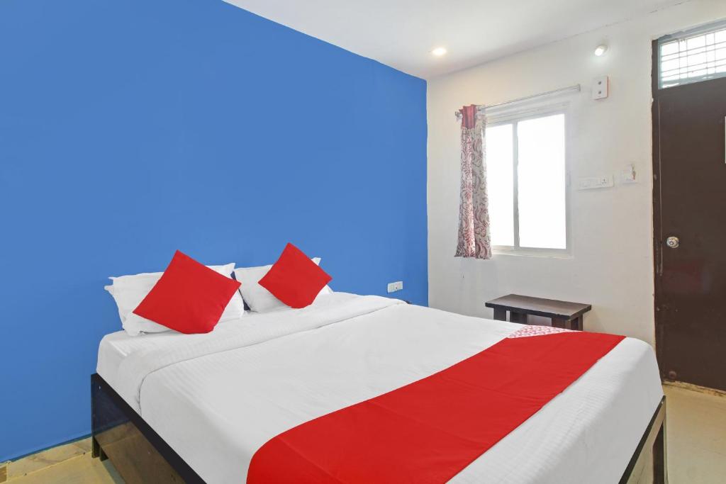 a bedroom with a large bed with red pillows at Hotel O A Delight Residency in Surūrnagar