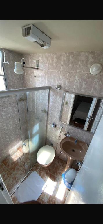 a bathroom with a shower and a toilet and a sink at Hotel Gerais Business in Montes Claros