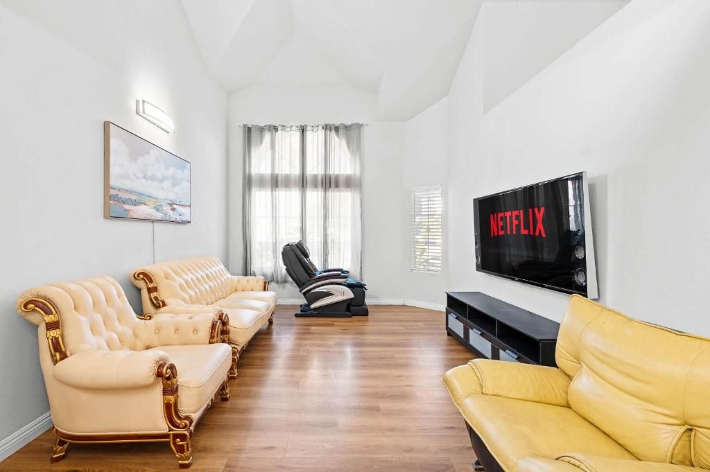 a living room with couches and a flat screen tv at Bright Family Getaway w Garage&Prime SoCal Location in Valinda