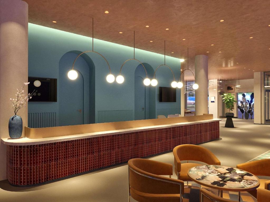 a lobby with a reception counter and chairs and lights at Hotel Lycium Debrecen - Handwritten Collection in Debrecen