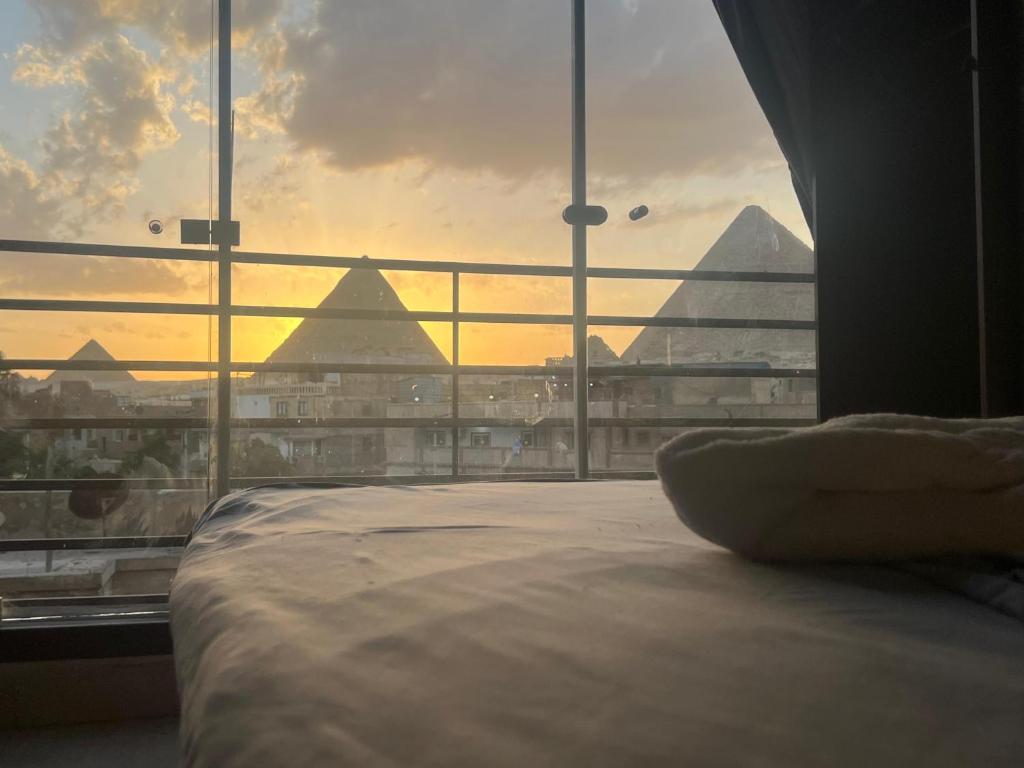 a bedroom with a large window with a view of pyramids at Continental de las pirámides in Cairo