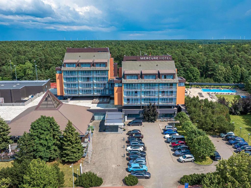 an aerial view of a hotel with cars parked in a parking lot at Mercure Palanga Vanagupe Resort & SPA in Palanga