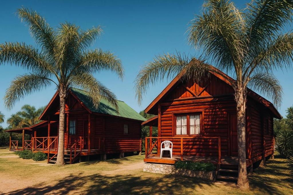 a wooden house with two palm trees next to it at Cabaña con pileta & jardín- a minutos del centro y la playa in Miramar