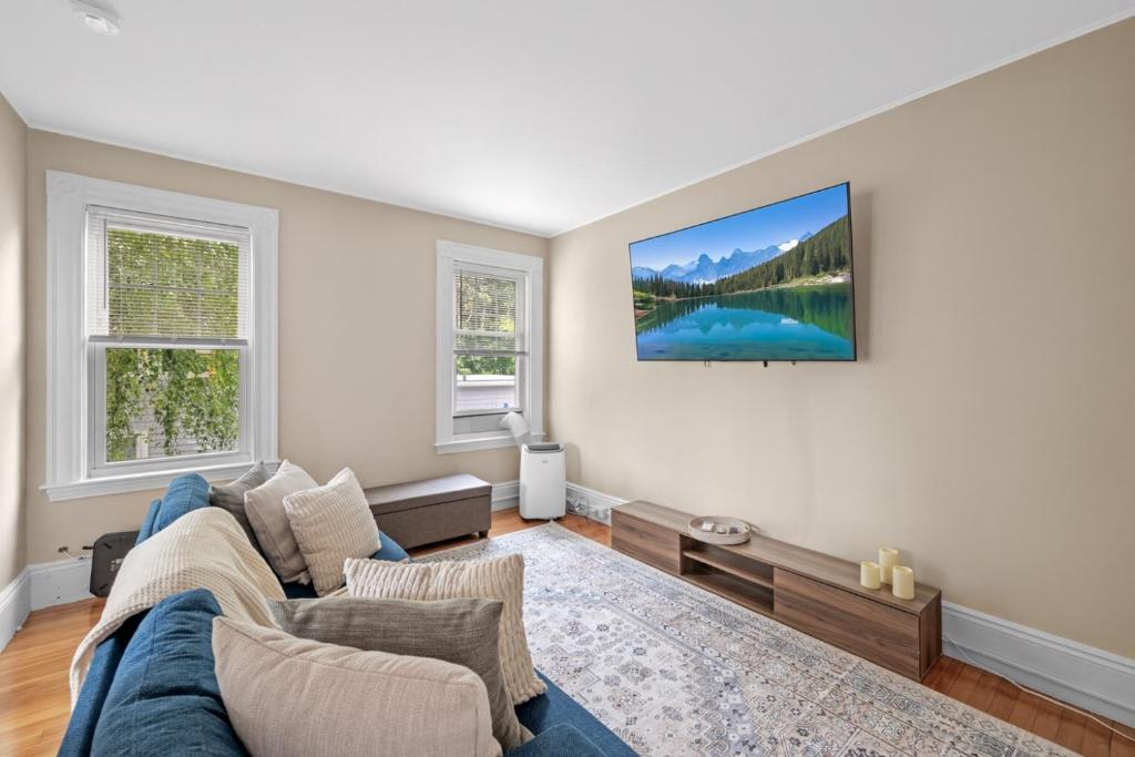 セーラムにあるSalem 3 Bedroom with Gameroom, Balcony, Parking, and moreの青いソファと2つの窓があるリビングルーム