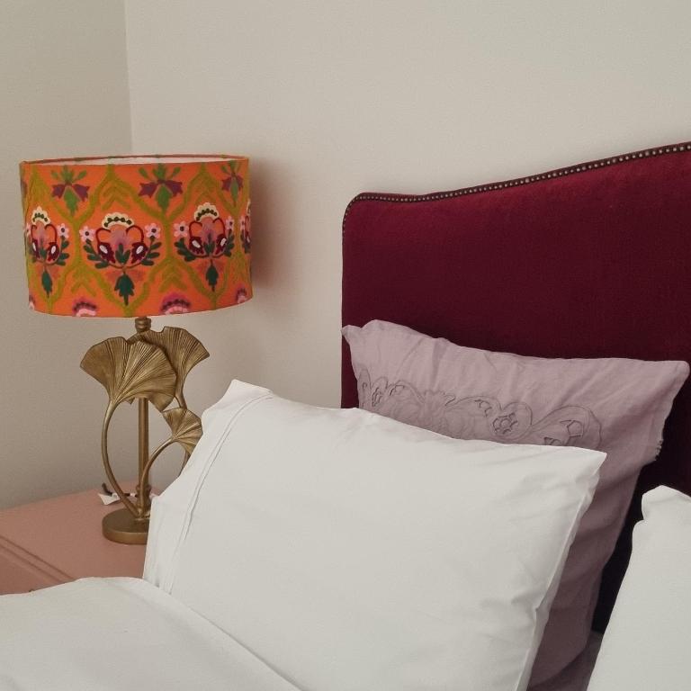 a bed with a lamp and a white pillow at Miss Victoria in Nerrina