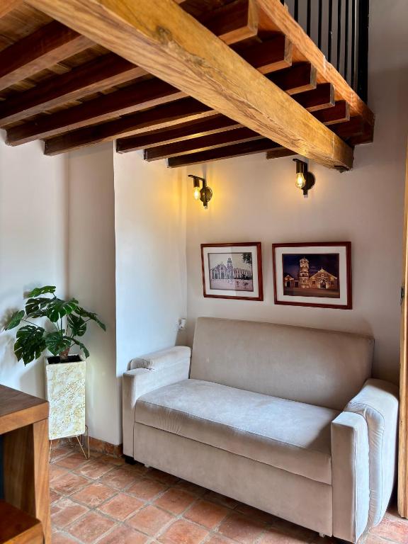 a couch in a living room with wooden ceilings at El monarca in Mompos