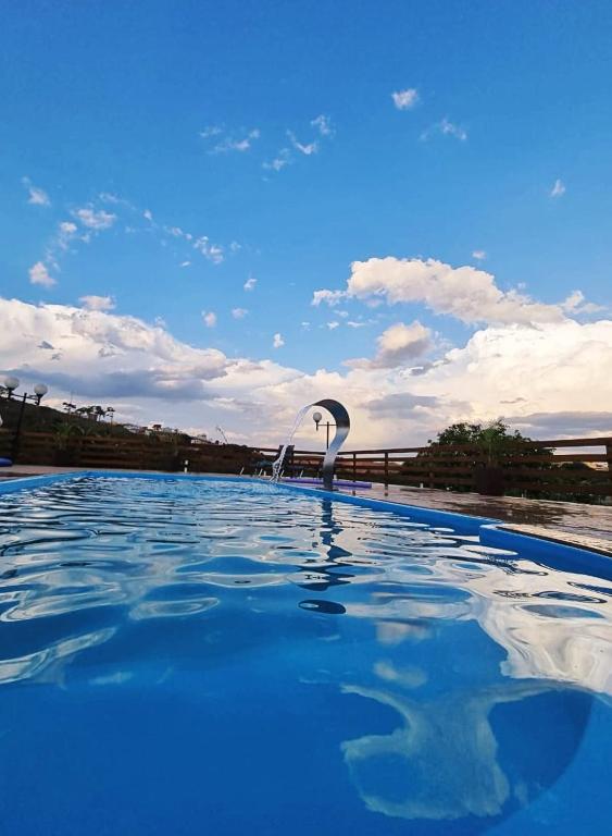 a large swimming pool with a clear blue sky at Tríade Chalé da Canastra 1 in São Roque de Minas