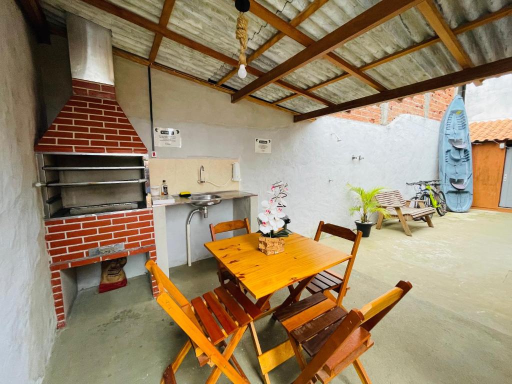 een tafel en stoelen in een keuken met een fornuis bij Chalé 2 em Ilhabela in Ilhabela