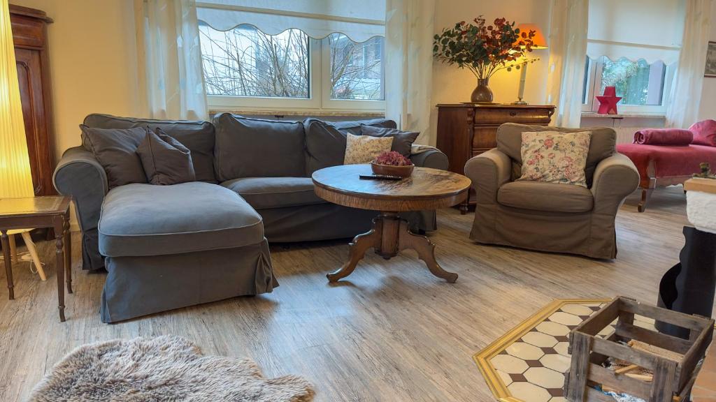 a living room with a couch and a table and chairs at Haus Küstenzauber am Deich in Döse