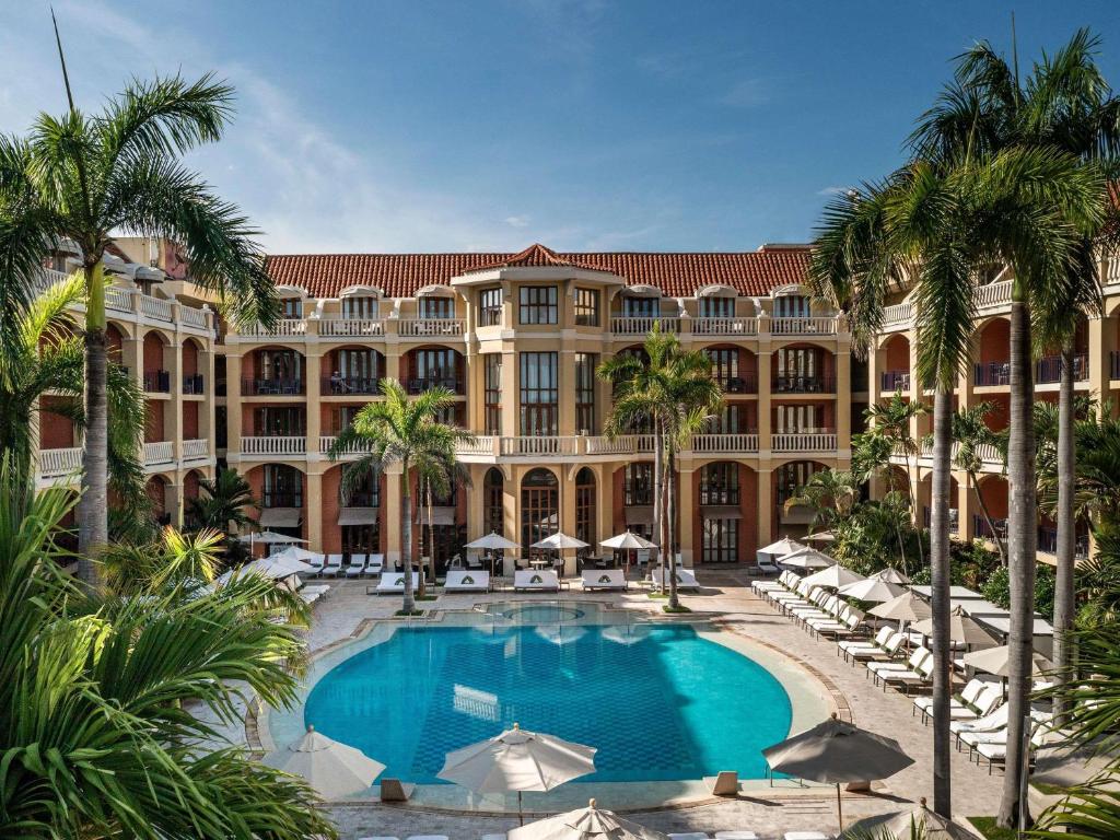 an exterior view of a resort with a pool and palm trees at Sofitel Legend Santa Clara Cartagena in Cartagena de Indias