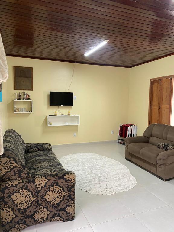 Una sala de estar con un sofá y un televisor. en Alugo casa por temporada, en Belém