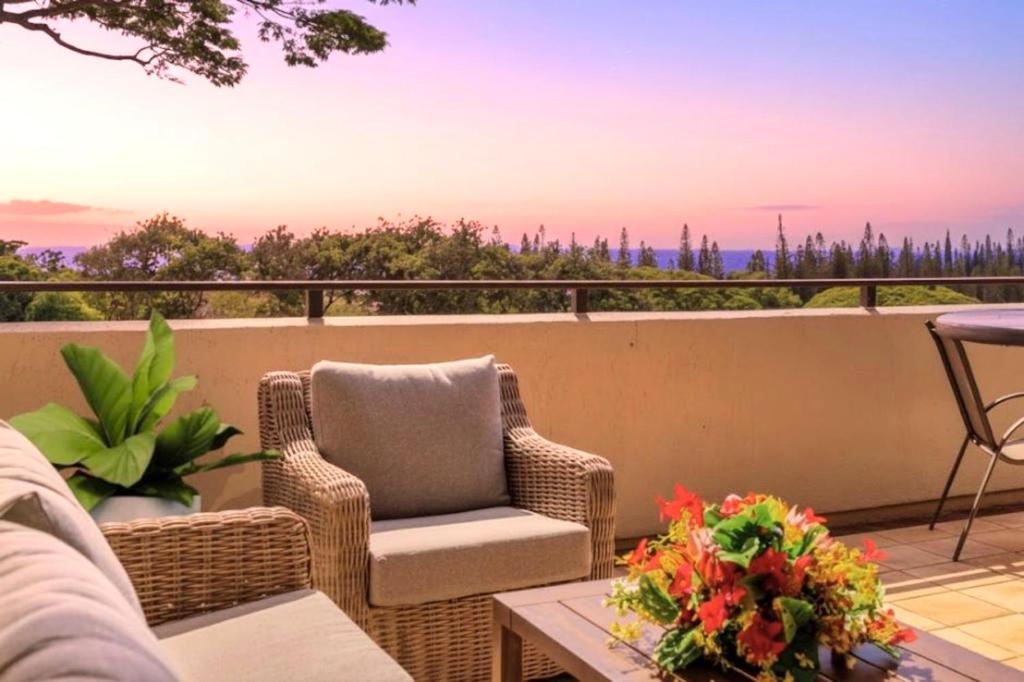 a patio with wicker chairs and a table on a balcony at NEW KBM Resorts FREE CAR Kapalua Golf Villas 1-Bedroom Condo with Spacious Lanai and Golf Course Views KGV-18T4 in Kapalua
