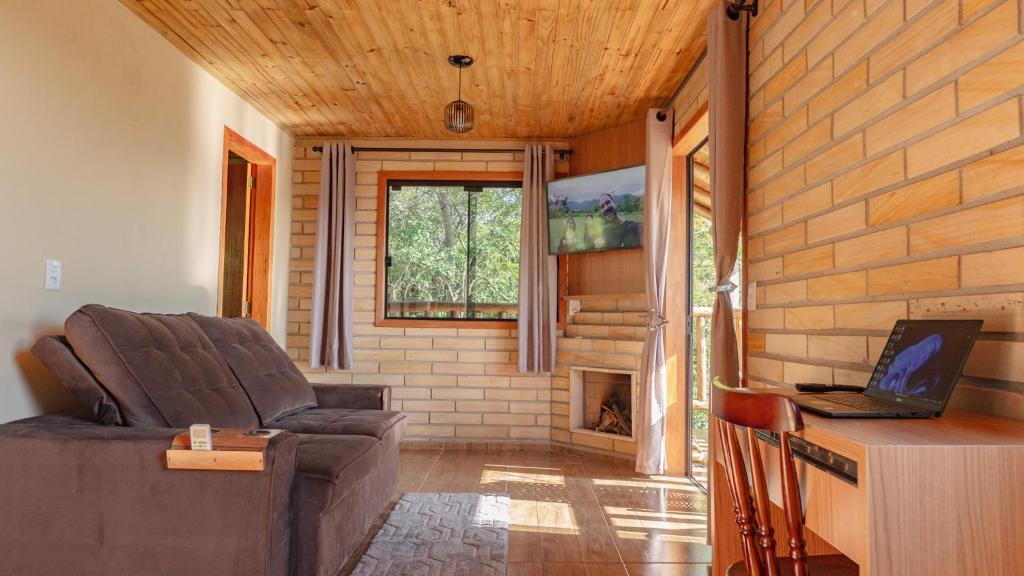 a living room with a couch and a fireplace at Morada Paraíso dos canyons in Praia Grande