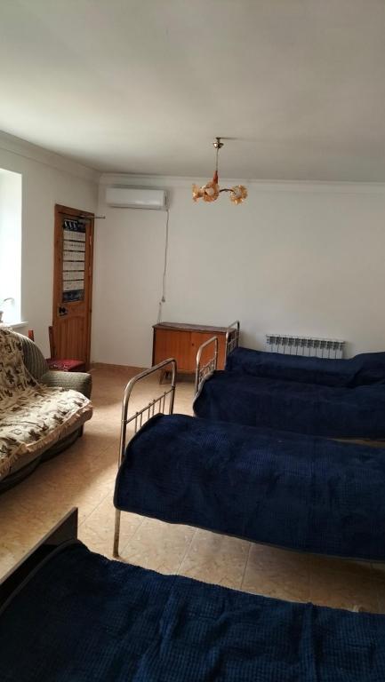 una sala de estar con dos camas y un sofá en Хостел Москева, en Aktobe