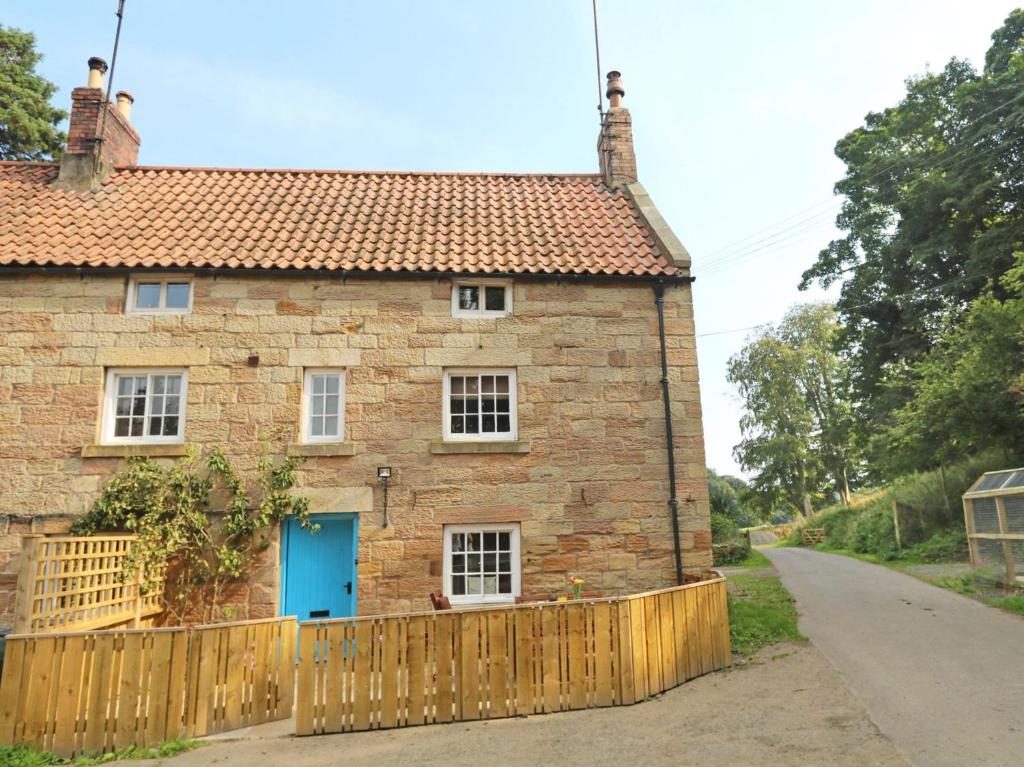 une vieille maison en briques avec une porte bleue dans l'établissement 2 Bed in Warkworth CN004, à Warkworth