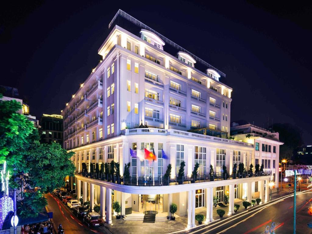 a large white building with lights on top of it at Hotel de l'Opera Hanoi - MGallery in Hanoi