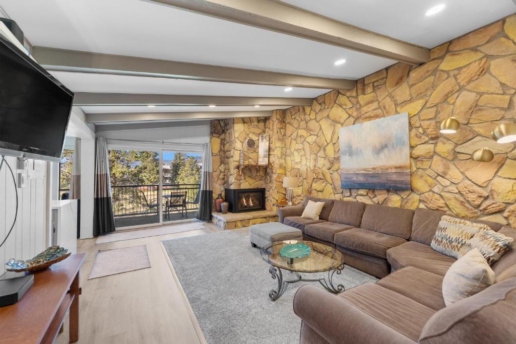 a living room with a couch and a stone wall at Lake Cliffe #305 Building A in Dillon