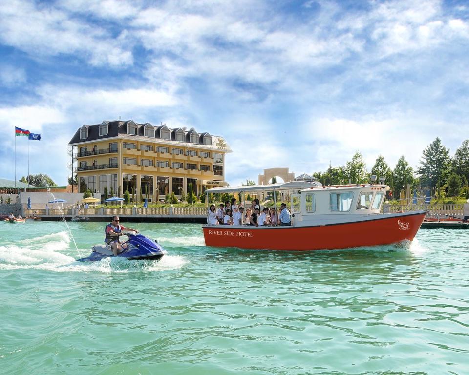a group of people riding on a boat in the water at River Side Hotel in Mingachevir