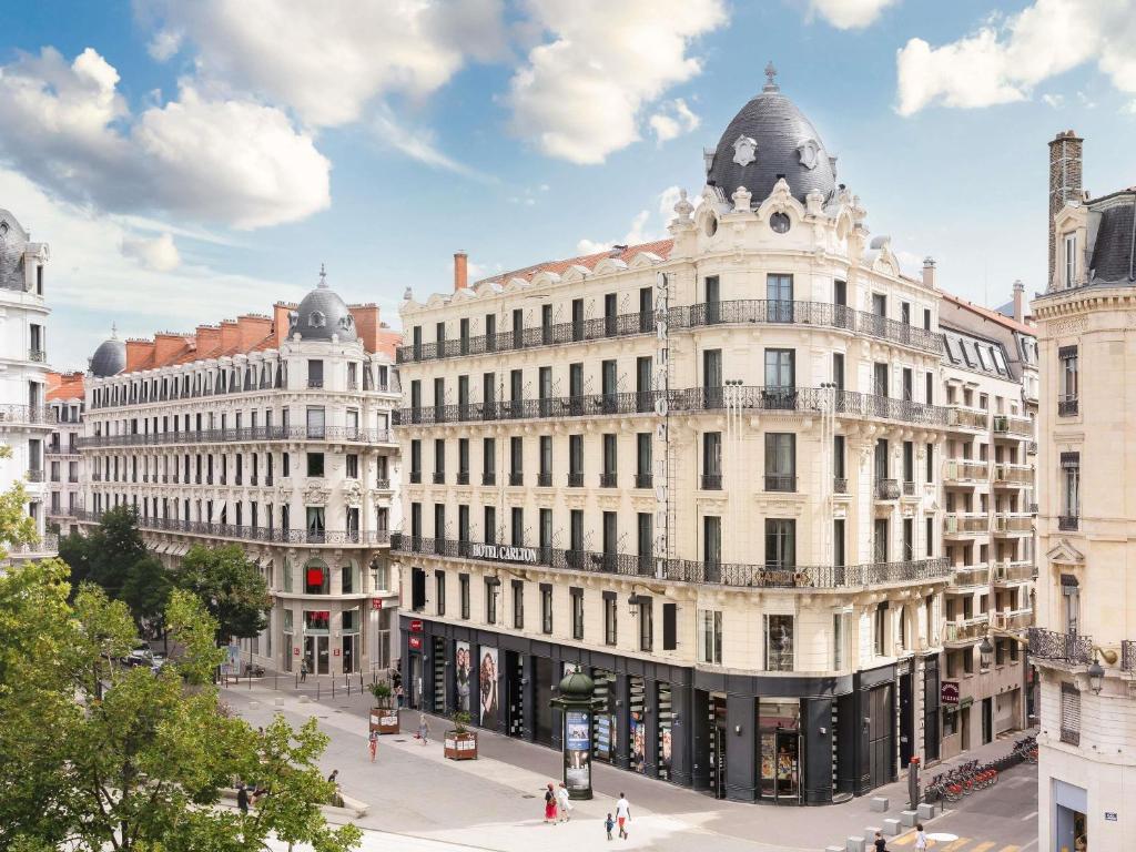 a large white building on a city street at Carlton Hotel Lyon - MGallery Collection in Lyon