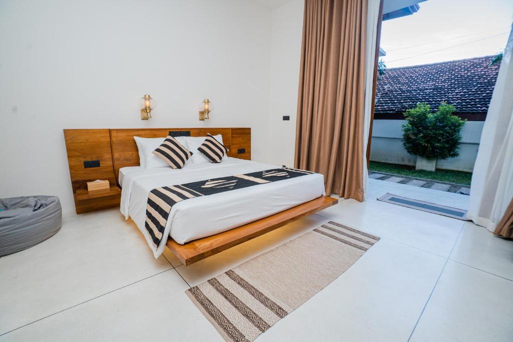 マータラにあるMadiha Venusのベッドと大きな窓のある寝室