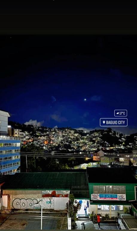 a view of a city at night with a street sign at Your Own Room at a Shared Apartment with Balcony in Baguio