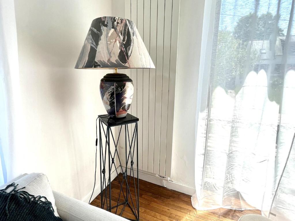 a lamp on a stand in a room with a window at Charmante maison entre Port Tudy et le Bourg à Groix - FR-1-813-34 in Groix