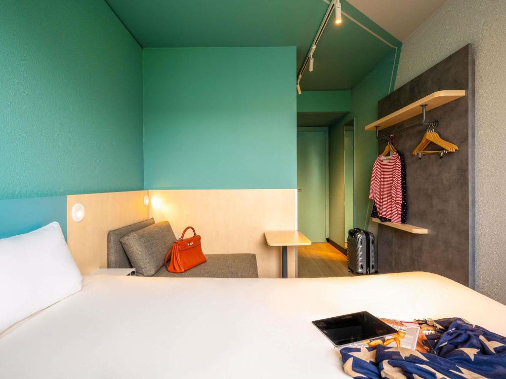 a bedroom with a bed and a blue wall at ibis budget Berlin Kurfürstendamm - neu renoviert in Berlin