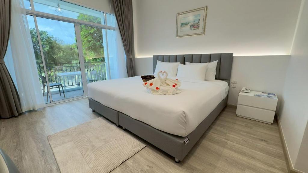 a bedroom with a bed with a stuffed animal on it at Baan Suan Khun Ta and Golf Resort in Ubon Ratchathani