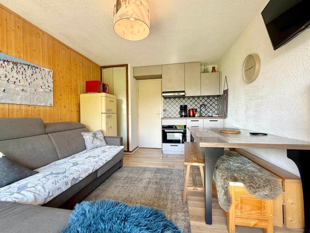 un piccolo soggiorno con divano e cucina di Appartement cosy avec terrasse et parking proche centre - FR-1-505-235 a Notre-Dame-de-Bellecombe