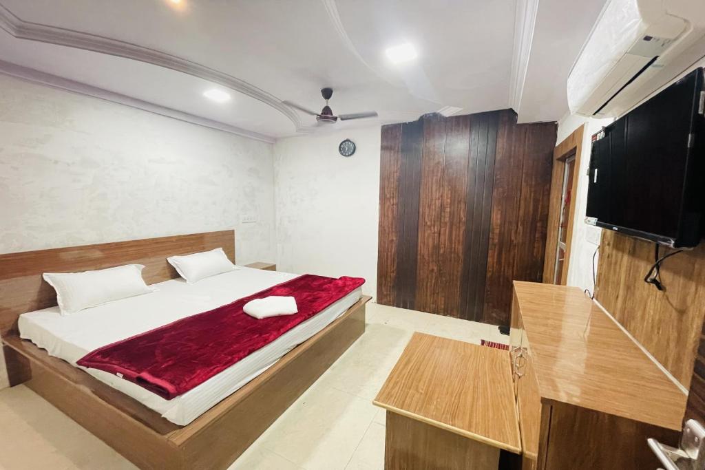 ein Schlafzimmer mit einem Bett und einem Flachbildfernseher in der Unterkunft OYO The 3 Star Hotel in Jabalpur