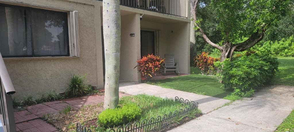 a house with a porch with a grass yard at Deerfield Beach vacation condo in Deerfield Beach