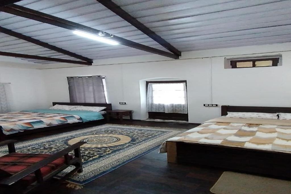 ein großes Zimmer mit zwei Betten und einem Fenster in der Unterkunft Hotel O Home Heritage Homestay in Takdāh