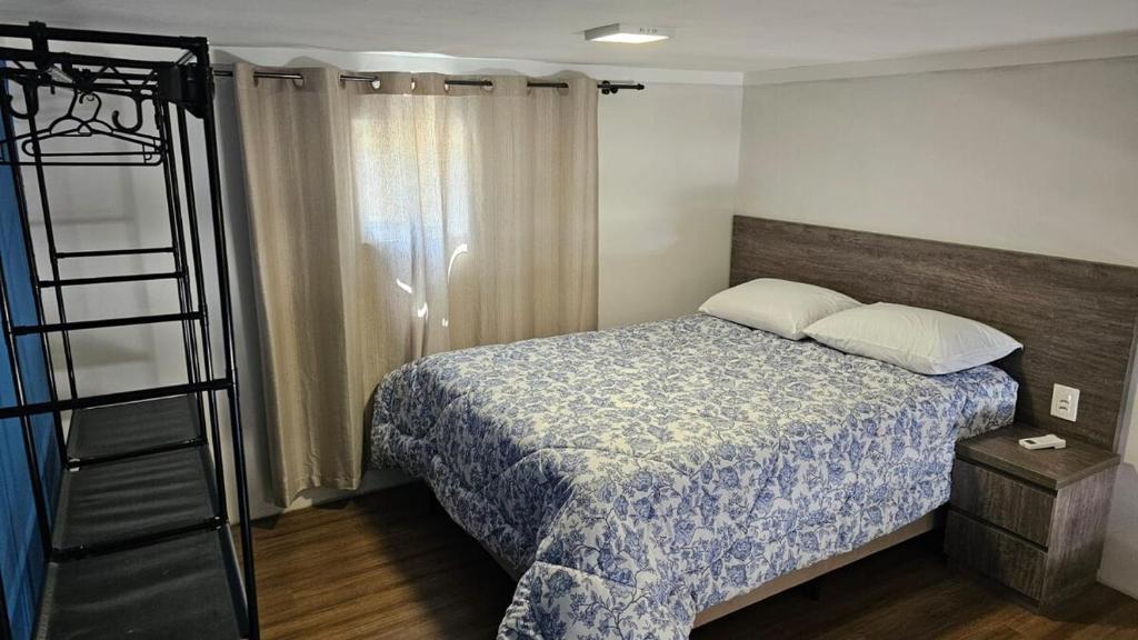 a small bedroom with a bed and a ladder at Apartamento Firenze - Conforto e Estilo na Serra Gaúcha in Bento Gonçalves